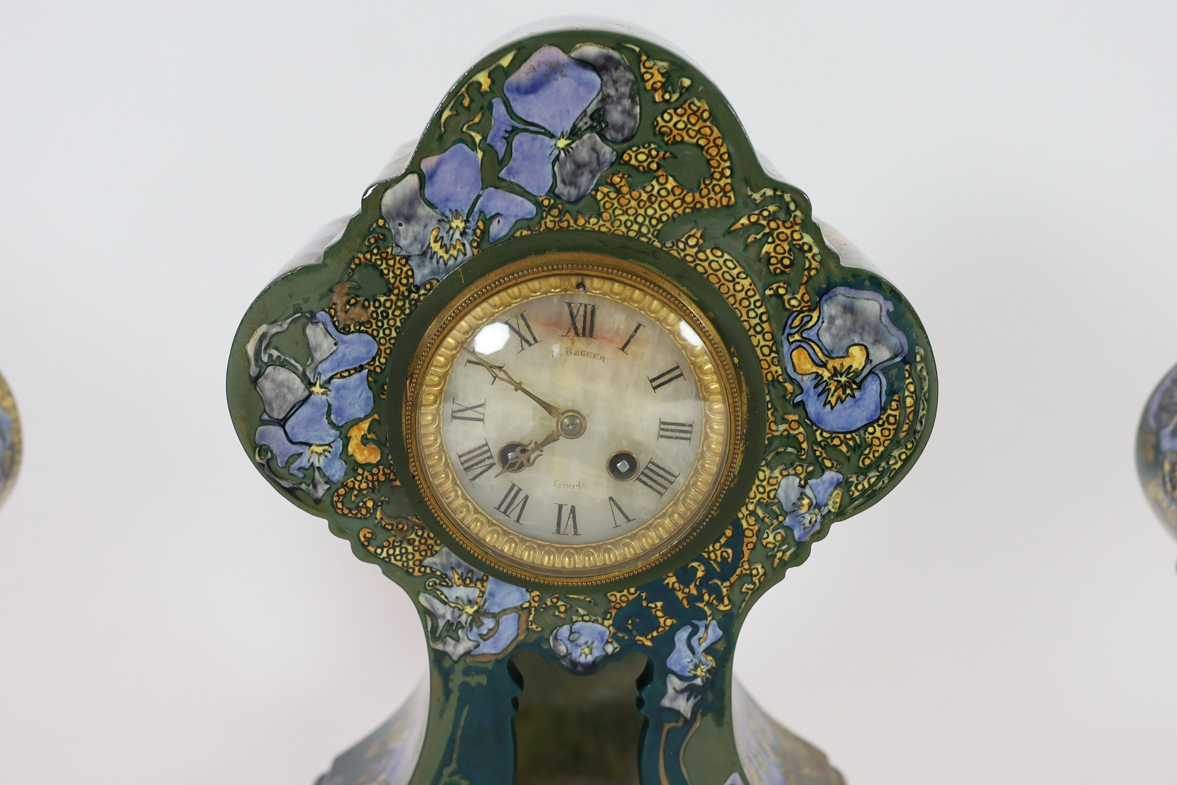 A Rozenberg Art Nouveau earthenware three piece clock garniture, clock 45 cm high